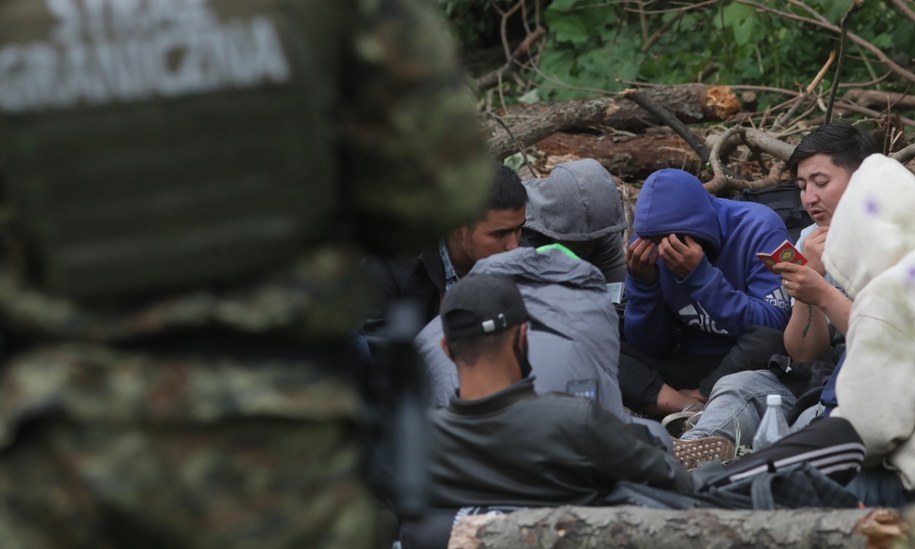 Grupa uchodźców i straż graniczna w pobliżu miejscowości Usnarz Górny k. Krynek (zdjęcie archiwalne) /Artur Reszko /PAP