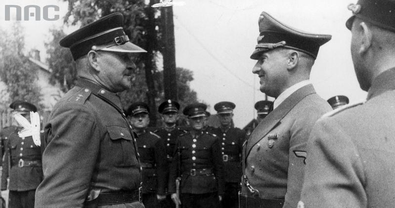 Gubernator Hans Frank (z prawej) przyjmuje meldunek od komendanta oddziału polskiej policji (granatowej). W tle widoczni stojący w dwuszeregu polscy policjanci /Z archiwum Narodowego Archiwum Cyfrowego