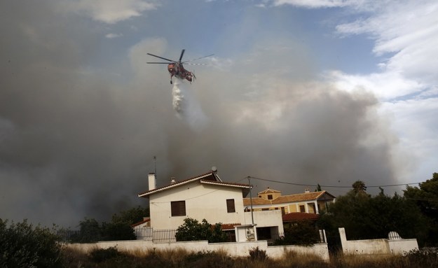 Helikopter zrzuca wodę na dom na północnych przedmieściach Aten /ALEXANDROS VLACHOS /PAP/EPA