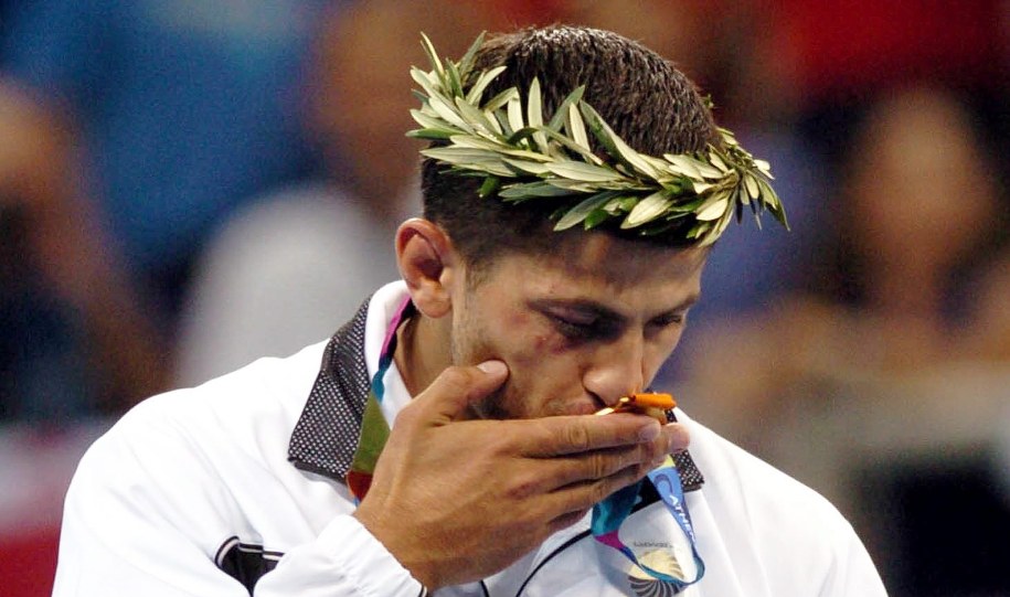 Igrzyska w Atenach. Zurab Zwiadauri całuje złoty medal, który wywalczył w judo w kategorii 90 kg /Dimitris Panagos /PAP/EPA