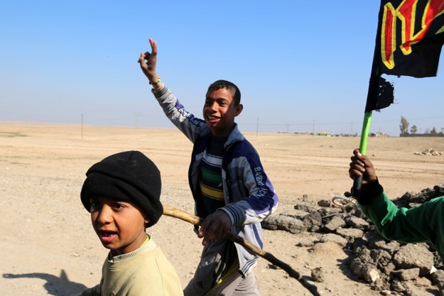 Irackie dzieci biegną za wojskowym samochodem zmierzającym w kierunku południa Mosulu /BASEL RASOL  /PAP/EPA