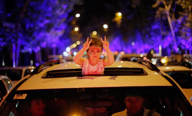 Irańska dziewczynka i jej rodzice świętują na ulicach Teheranu zawarcie porozumienia nuklearnego /Abedin Taherkenareh   /PAP/EPA