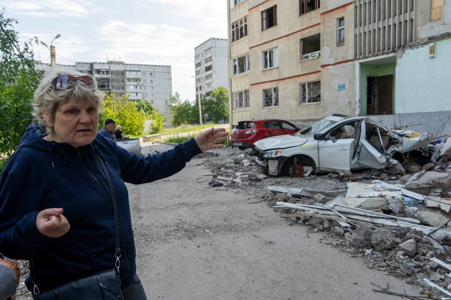 Jedna z mieszkanek przed zniszczonym blokiem w Charkowie /Mykola Kalyeniak /PAP