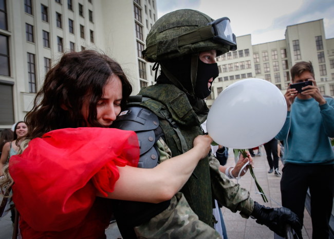 Jedna z protestujących kobiet przytula żołnierza /TATYANA ZENKOVICH  /PAP/EPA