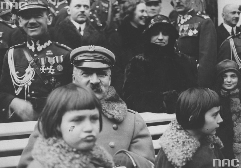 Józef Piłsudski (siedzi na pierwszym planie) z córeczkami Wandą (siedzi z prawej strony) i Jadwigą (przed marszałkiem) w otoczeniu gości przybyłych z życzeniami imieninowymi. /Z archiwum Narodowego Archiwum Cyfrowego