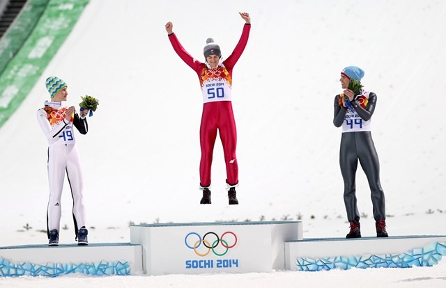 Kamil Stoch skacze z radości na podium /Grzegorz Momot /PAP