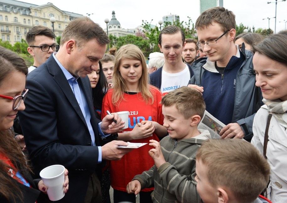Kandydat na prezydenta Andrzej Duda (L) rozdaje autografy i częstuje kawą przed wejściem na stację metra Centrum w Warszawie /Marcin Obara /PAP