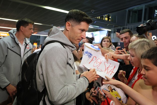 Kapitan piłkarskiej reprezentacji Polski Robert Lewandowski (C) rozdaje autografy podczas powitania na warszawskim lotnisku Okęcie /Paweł Supernak /PAP