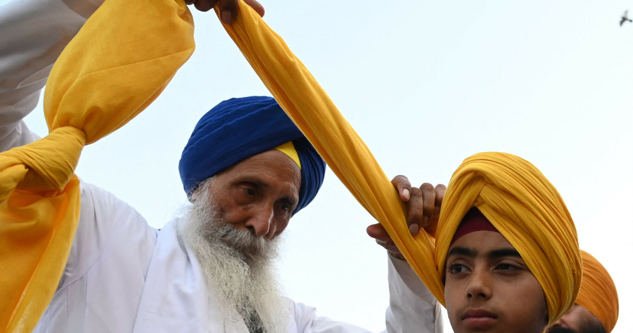 Kapłan sikhijski zawiązuje turban wokół głowy chłopca podczas obchodów "Dnia Turbana", w Amritsar 13 kwietnia 2023 r. (Foto Narinder NANU / AFP) /East News