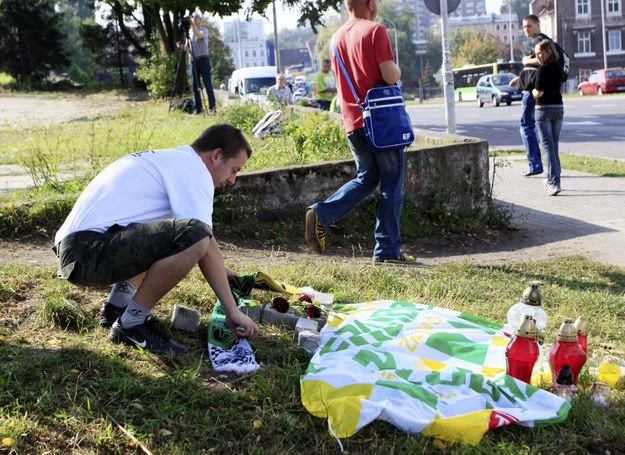 Kibic przy ułożonym z kostki krzyżu przykrytym flagą w barwach Stelmetu Falubazu Zielona Góra w miejscu, gdzie zginął potrącony przez policyjny nieoznakowany samochód kibic / 	Lech Muszyński    /PAP