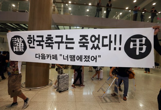 Kibice czekali na lotnisku na piłkarzy, trzymając baner "Koreański futbol nie żyje" /YONHAP SOUTH /PAP/EPA