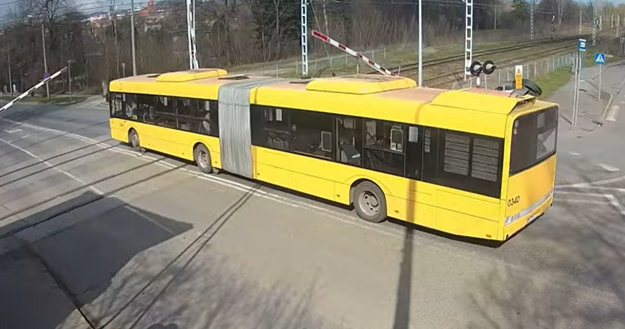 Kierowca autobusu zignorował czerwone światła oraz opuszczające się zapory i przejechał przez tory kolejowe. /Business Control MONITORING/ You Tube/ zrzut ekranu /