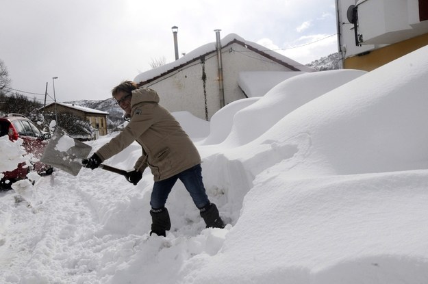 Kobieta odgarnia śnieg przed swoim domem w Kastylii-Leon na północy Hiszpanii /J. CASARES /PAP/EPA