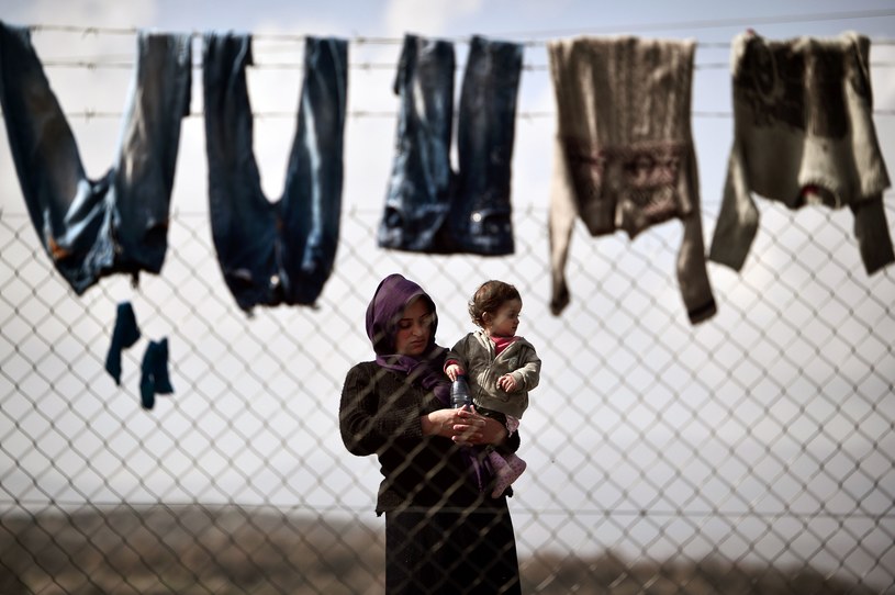 Kobieta trzyma na rękach dziecko w obozie dla uchodźców przy granicy macedońsko-greckiej /AFP