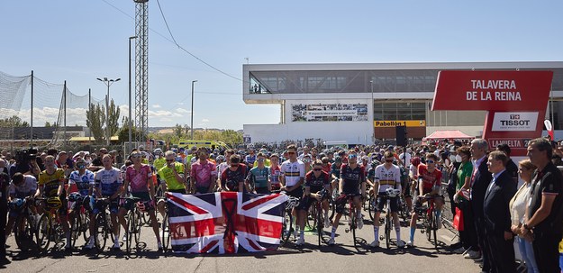 Kolarze w wyścigu Vuelta a España 2022 trzymają flagę Wielkiej Brytanii z czarną wstążką, aby oddać hołd zmarłej królowej Elżbiecie II. /MANU REINO /PAP/EPA