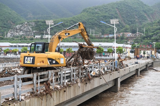Koparka usuwa z mostu połamane konary i inne elementy naniesione przez wodę /XINHUA / Ju Huanzong /PAP/EPA