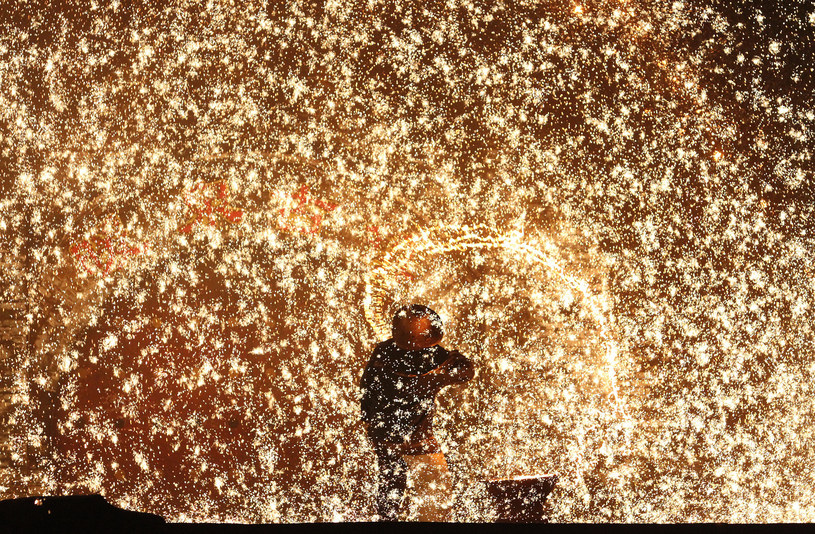 Kowale rozrzucają roztopione żelazo, tworząc "fajerwerki" z iskier /Visual China Group via Getty Images/Visual China Group  /Getty Images