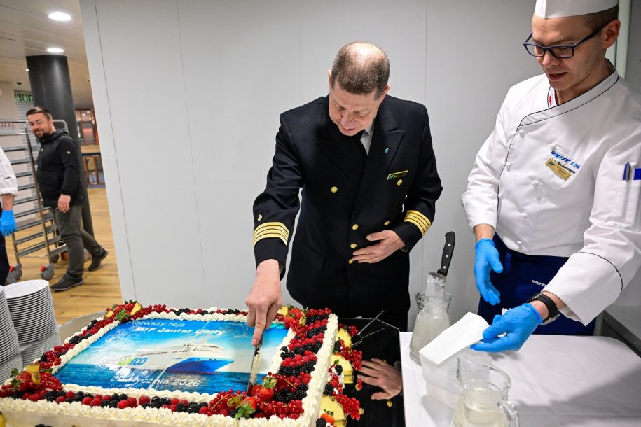 Kpt. ż.w. Wojciech Żukowski kroi okolicznościowy tort na pokładzie nowego promu Jantar Unity / 	Marcin Bielecki    /PAP