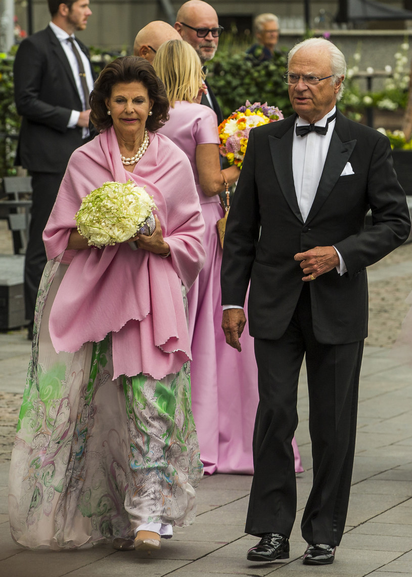 Królowa Sylwia Sommerlath wraz z mężem, królem Karolem XIV Gustawem. Lekka, wykonana z delikatnego materiału sukienka i bukiet kwiatów ożywiają twarz królowej /Getty Images
