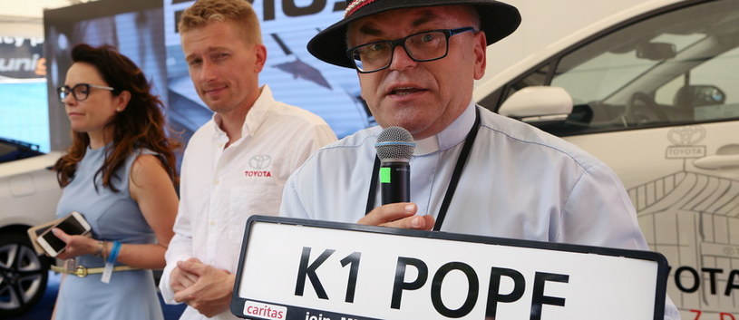 Ks. Bogdan Kordula prezentuje tablicę rejestracyjną K1 POPE, która przymocowana będzie do jednego z czterech samochodów papieża Franciszka /Fot. Stanisław Rozpędzik /PAP
