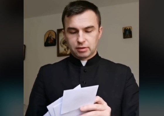 Ks. Sebastian Picur pokazuje zawartość kopert po kolędzie /