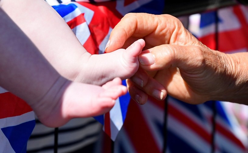 Księżna Kamila trzymająca w dłoniach stopę dziecka podczas spotkania z mieszkańcami Londynu /Getty Images