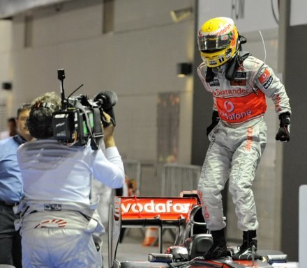 Lewis Hamilton cieszy się ze zwycięstwa w GP Singapuru. /AFP