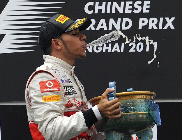 Lewis Hamilton z radości po wygranej "pluje" szampanem /AFP