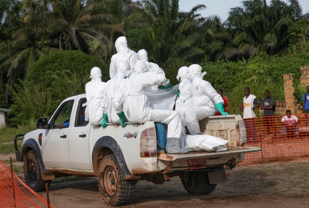 Liberyjscy pracownicy ochrony zdrowia w specjalnych kombinezonach jadą pochować kobietę, która zmarła na gorączkę krwotoczną Ebola /AHMED JALLANZO  /PAP/EPA