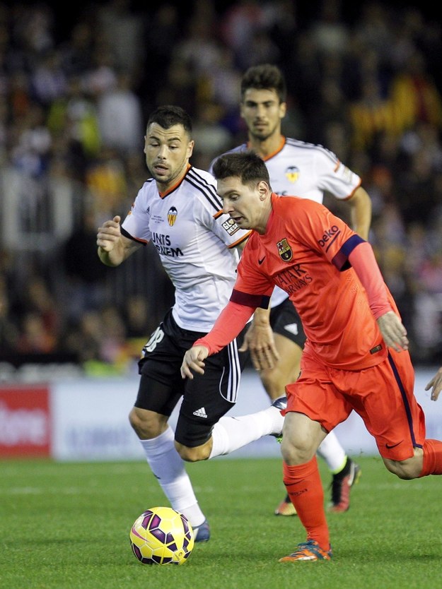 Lionel Messi w meczu Barcelony z Valencią. Po lewej Javi Fuego /MANUEL BRUQUE    /PAP/EPA