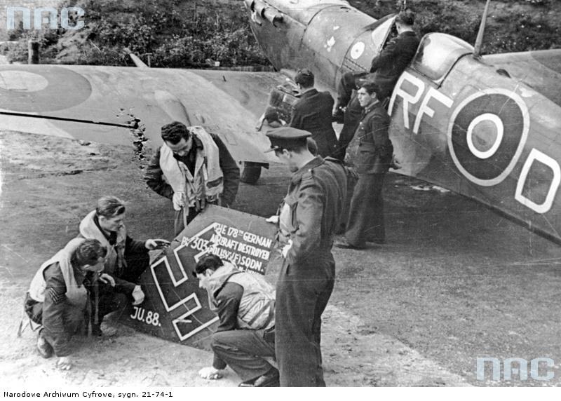 Lotnicy polskiego Dywizjonu 303 oglądają szczątki zestrzelonego samolotu niemieckiego "Ju 88". Z prawej widoczny samolot "Spitfire" /Z archiwum Narodowego Archiwum Cyfrowego