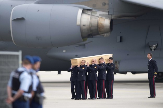 Lotnisko w Eindhoven. Żołnierze w galowych mundurach wynoszą z samolotu trumnę z ciałem ofiary katastrofy /MARCEL VAN HOORN /PAP/EPA