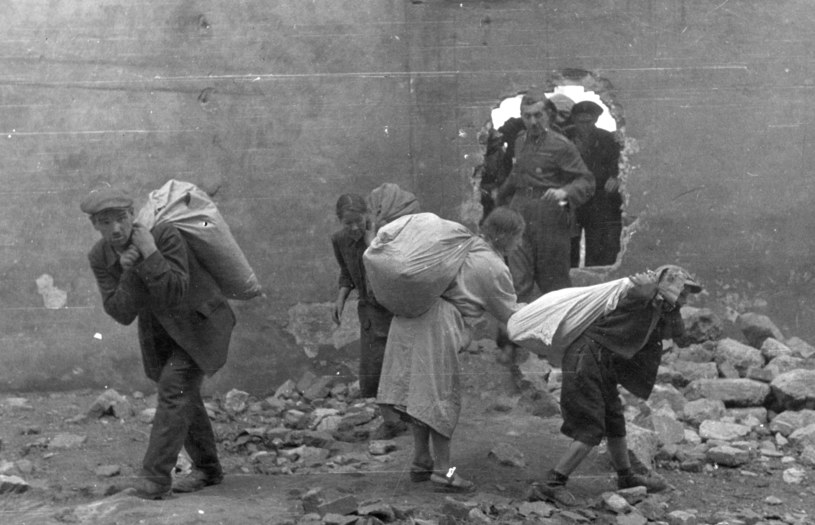Ludność cywilna wynosząca worki z pszenicą przez wybitą dziurę w murze, sierpień 1944 r. /Andrzej Ancuta  /Muzeum Powstania Warszawskiego