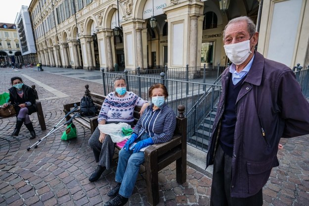 Ludzie noszą ochronne maski na twarz, gdy spotykają się w Turynie /Tino Romano /PAP/EPA