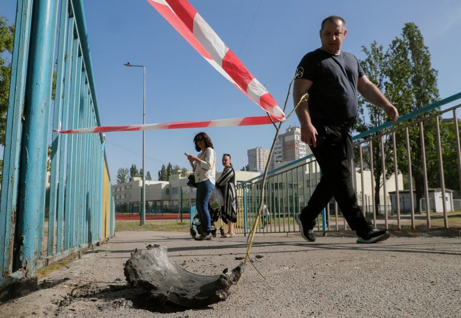 Ludzie przechodzący obok fragmentów pocisku, zestrzelonego nad Kijowem /EPA/SERGEY DOLZHENKO /PAP/EPA