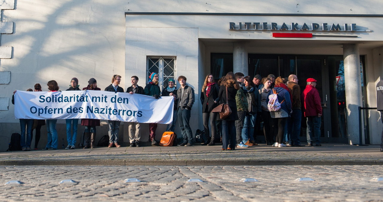 Ludzie z transparentem "Solidarność z ofiarami nazistowskiego terroru" przed Ritterakademie, gdzie toczy się proces /PAP