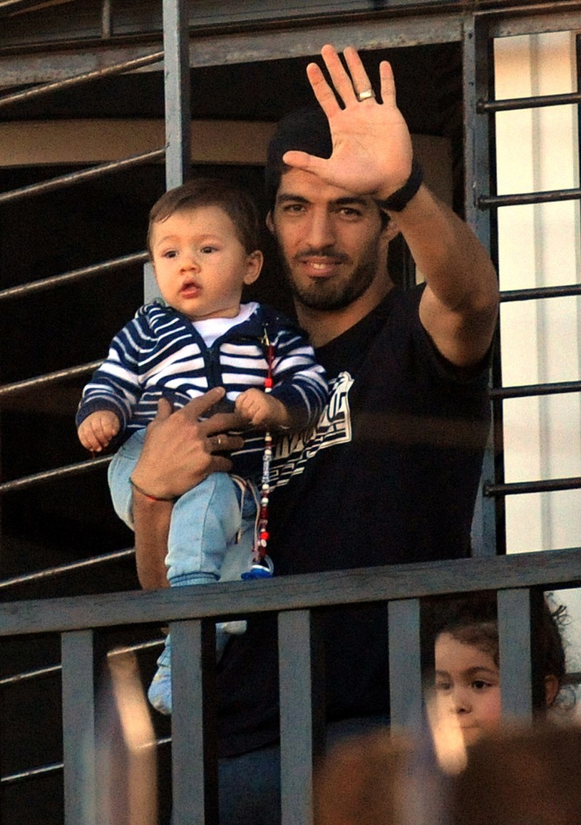 Luis Suarez z dzieckiem pozdrawia fanów /AFP