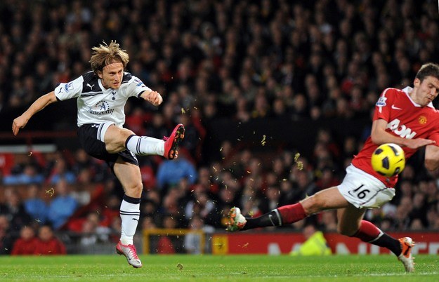 Luka Modrić strzela na bramkę Manchesteru United. Piłkę próbuje zatrzymać Michael Carrick /AFP