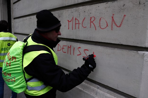 "Macron - dymisja!" pisze na murze przedstawiciel ruchu "żółtych kamizelek" podczas demonstracji w Paryżu sprzed tygodnia /ETIENNE LAURENT /PAP/EPA
