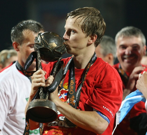 Marcin Baszczyński całuje mistrzowskie trofeum zdobyte z Wisłą Kraków. 2008 /Jacek Bednarczyk /PAP