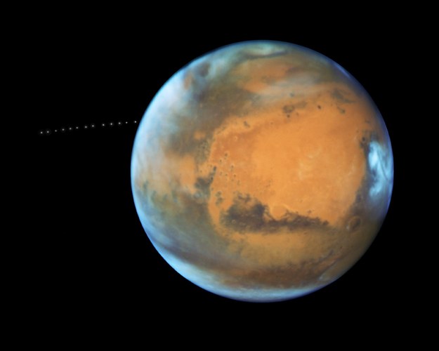 Mars w obiektywie teleskopu kosmicznego Hubble'a. Wiele ekspozycji pokazuje ruch księżyca Marsa, Fobosa. /NASA, ESA, and Z. Levay (STScI) /Materiały prasowe