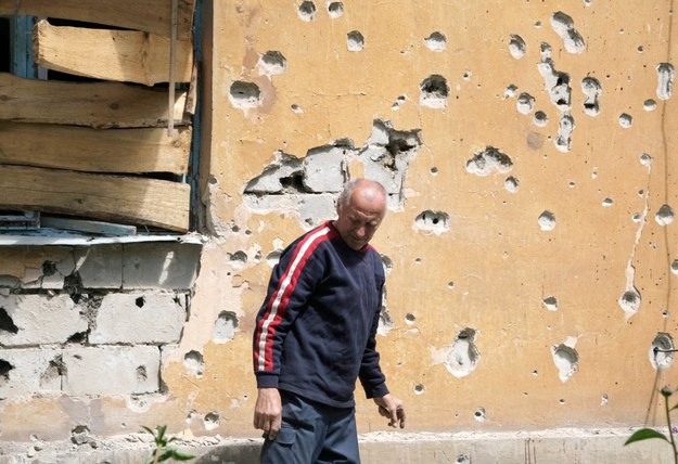 Mężczyzna na tle zniszczonego w bombardowaniu domu w Doniecku /ALEXANDER ERMOCHENKO /PAP/EPA