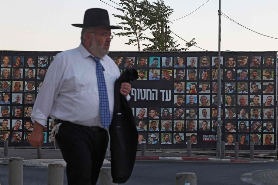 Mężczyzna przechodzi obok billboardu z portretami zakładników Hamasu /AHMAD GHARABLI / AFP /East News