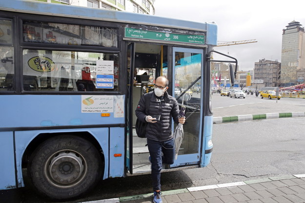 Mężczyzna z maseczką na twarzy, wysiadający z autobusu na ulicach Teheranu. W Iranie u 139 osób stwierdzono do tej pory obecność koronawirusa /Abedin Taherkenareh   /PAP/EPA