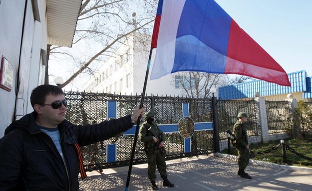 Mężczyźni trzymają rosyjskie flagi na Krymie /ZURAB KURTSIKIDZE /PAP/EPA