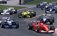 Michael Schumacher (z prawej) tuż po starcie obejmuje prowadzenie
