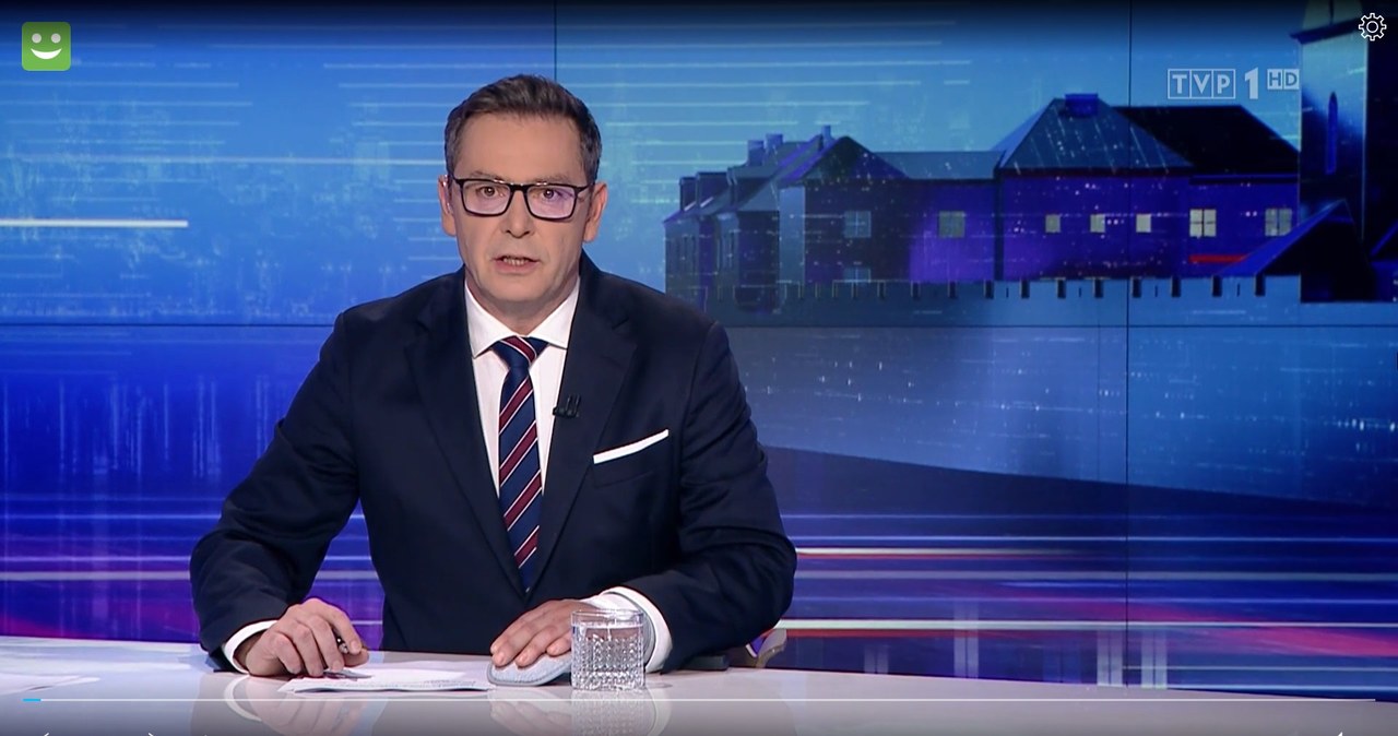 Michał Adamczyk zakrywał zagipsowaną rękę na wizji /wiadomosci.tvp.pl/ /materiał zewnętrzny