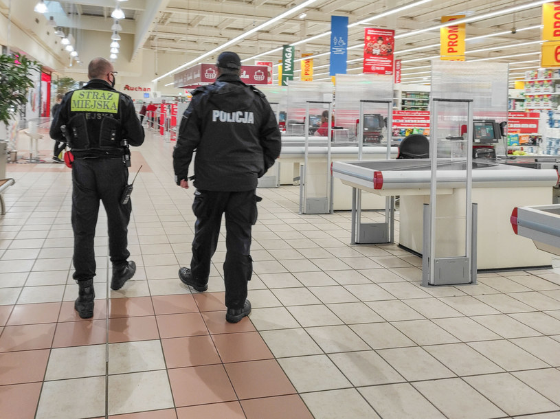Mieszane patrole funkcjonariuszy policji i straży miejskiej sprawdzają czy klienci sklepów maja założone maseczki ochronne. Zdj. z Łodzi /Tadeusz Wypych/REPORTER /East News