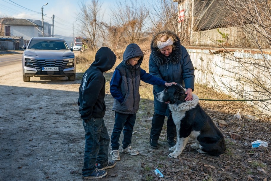 Mieszkańcy uspokajają rannego i przestraszonego psa w mieście Browary. /PAP/Vladyslav Musiienko /PAP/EPA