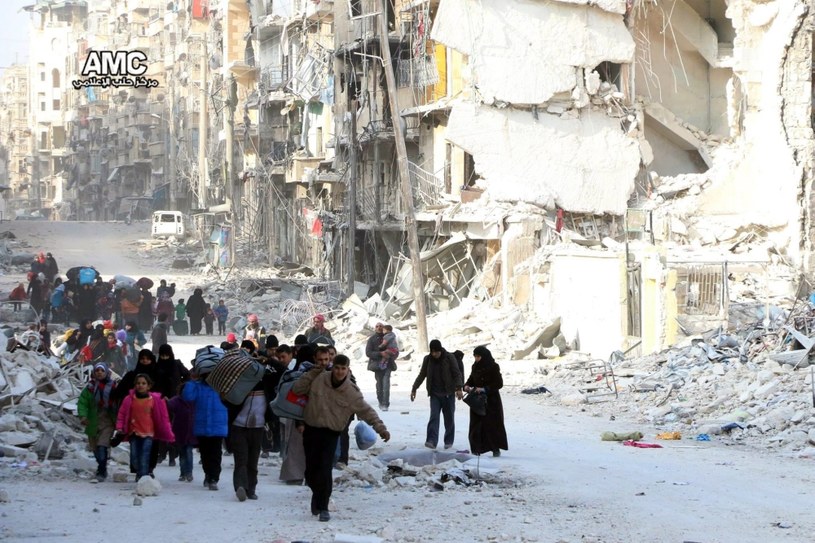 Mieszkańcy zdewastowanego przez bomby miasta Aleppo w Syrii /PAP/EPA